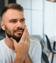 Concerned man touching his jaw