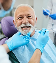 An older man smiling with dentures in Blaine